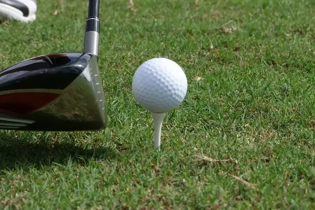 Golfbal op een tee naast een driver