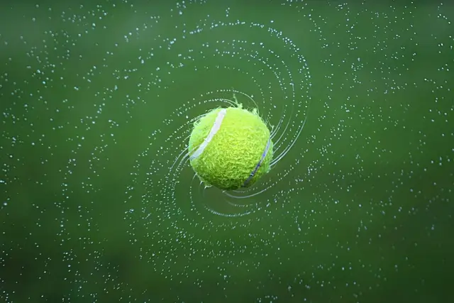 Tennisbal in de regen boven een groene baan