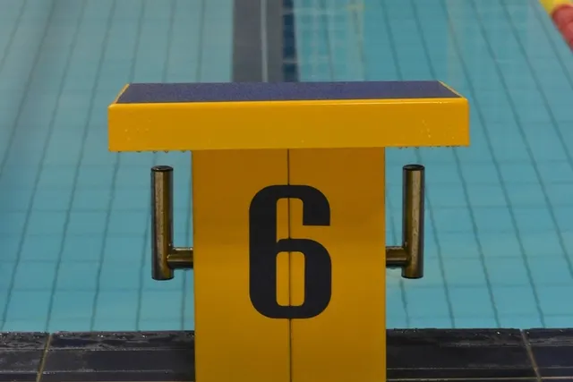 Geel startblok met nummer 6 aan de rand van een binnenbad